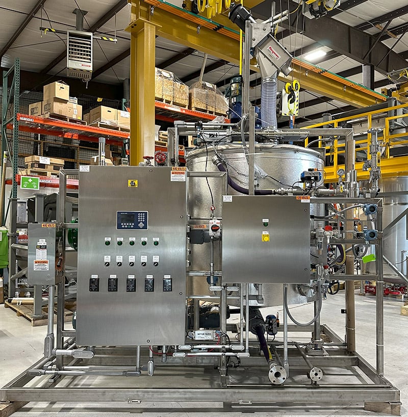 A starch makedown skid with a cooker is set up in a food processing facility. 